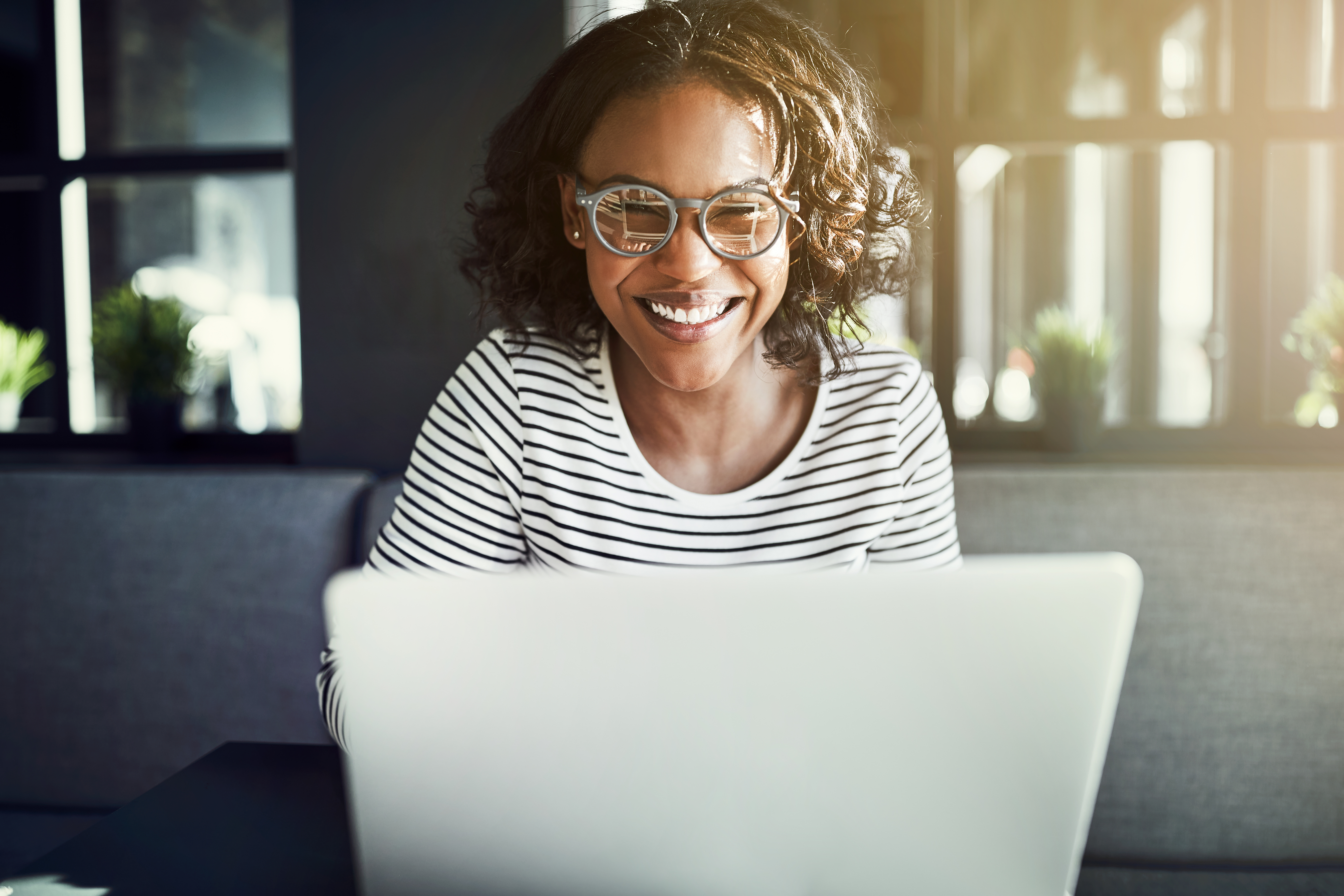 Empowering employment Delivery black woman smiling at a webinar on a computer screen