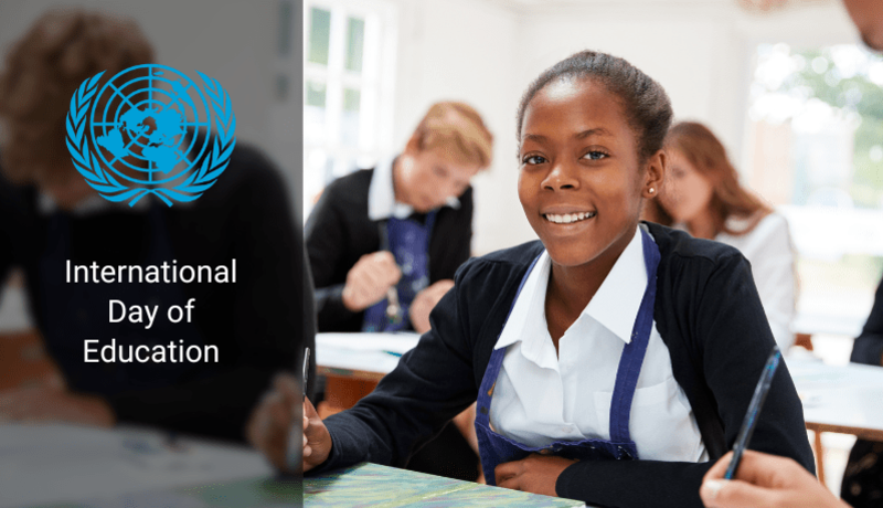 Black schoolgirl sat at desk with United Nations logo and 'International Day of Education' text