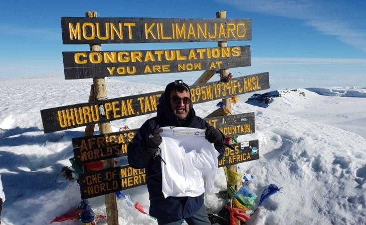Avtar Singh recruitment director standing in front kilomanjaro summit sign