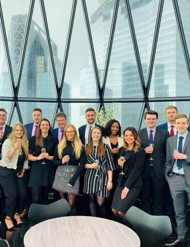 A group of recruitment consultants standing in front of big glass window