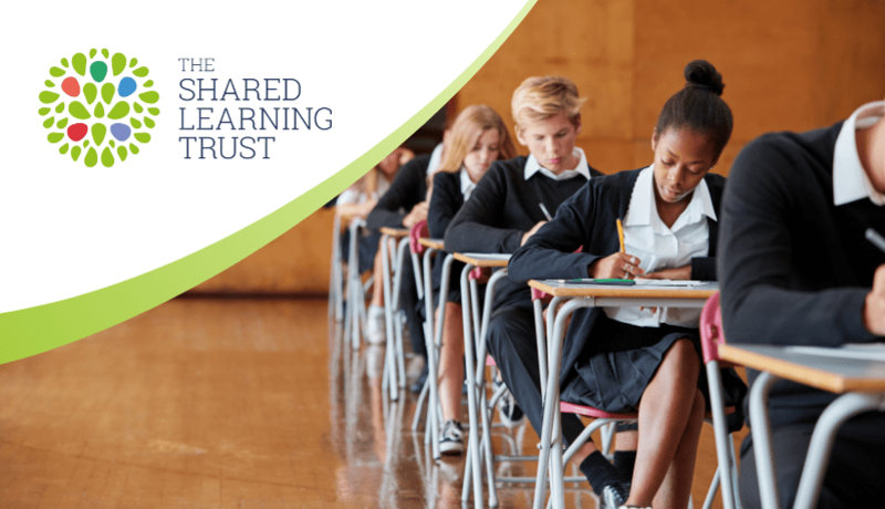 Several teenagers taking an exam with The Shared Learning Trust logo in corner