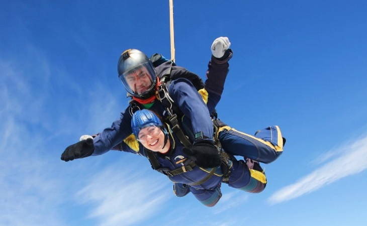 Charley Payne Sky dive for charity, Woman in tandem skydive with arms outstretched