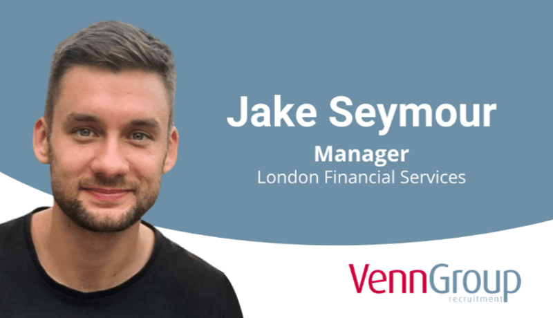 Man in front of promotion graphic